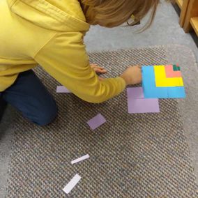 Lapsi rakentaa kuviota värikkäistä paloista