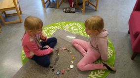 Kaksi lasta leikkii lattialla